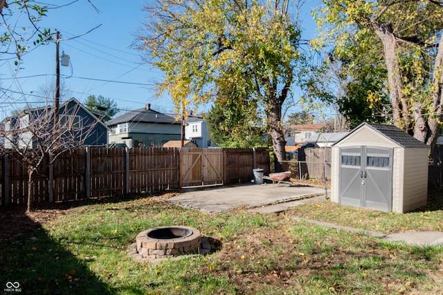 view of yard featuring a shed, an outdoor fire pit, and a patio area