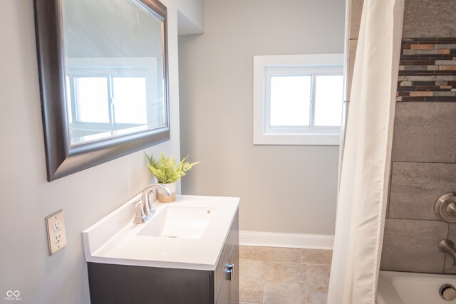 bathroom featuring vanity, shower / bath combo with shower curtain, and tile patterned flooring