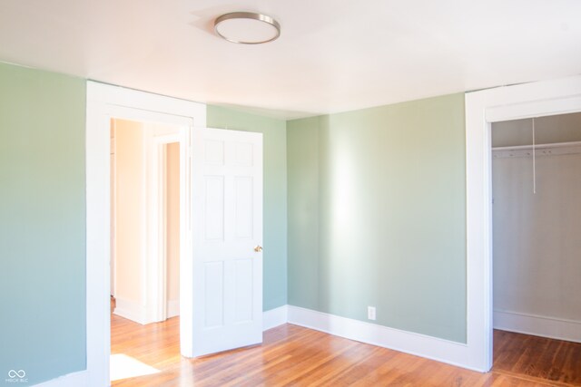 unfurnished bedroom with a closet and wood-type flooring