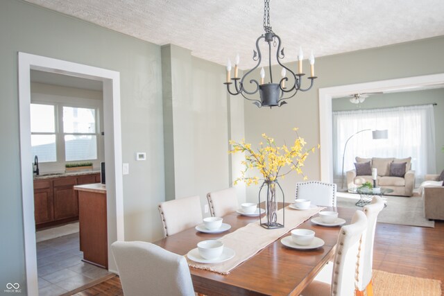 dining room featuring a chandelier, a textured ceiling, light hardwood / wood-style floors, and sink