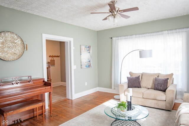 living room featuring a wealth of natural light, ceiling fan, a textured ceiling, and hardwood / wood-style flooring