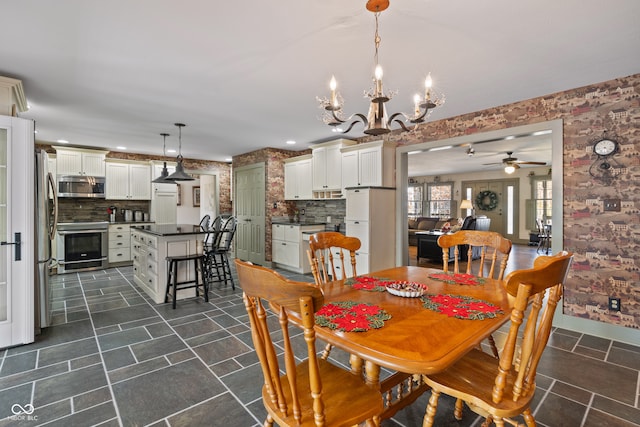 dining area featuring ceiling fan with notable chandelier