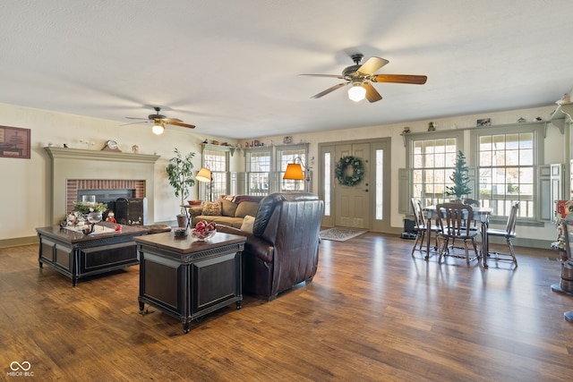 living room featuring ceiling fan, dark hardwood / wood-style flooring, and a fireplace