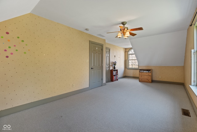 additional living space with light colored carpet, ceiling fan, and lofted ceiling