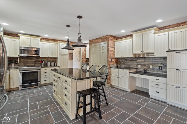 kitchen featuring a center island, backsplash, dark stone countertops, appliances with stainless steel finishes, and decorative light fixtures