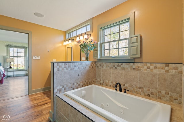 bathroom featuring hardwood / wood-style floors and a relaxing tiled tub