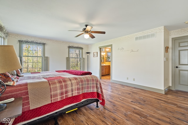 bedroom with ensuite bath, ceiling fan, and hardwood / wood-style flooring