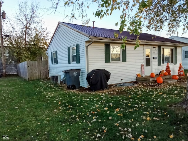 back of house featuring a yard and cooling unit