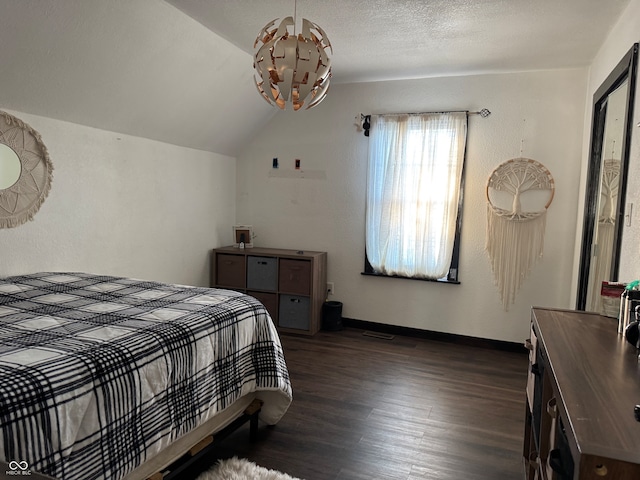 bedroom with a textured ceiling, dark hardwood / wood-style floors, and lofted ceiling