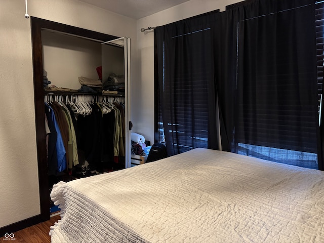 bedroom with wood-type flooring and a closet