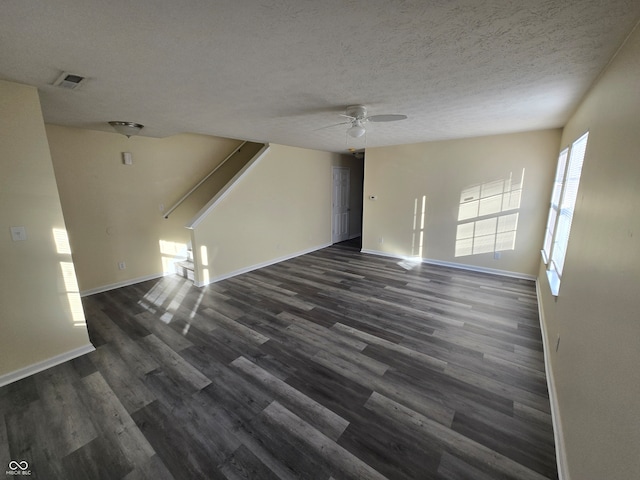 unfurnished living room featuring ceiling fan, dark hardwood / wood-style floors, and a textured ceiling