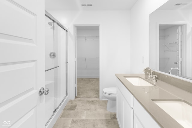 bathroom featuring vanity, toilet, and a shower with shower door