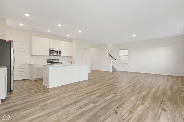 kitchen featuring white cabinets, light hardwood / wood-style floors, and stainless steel appliances