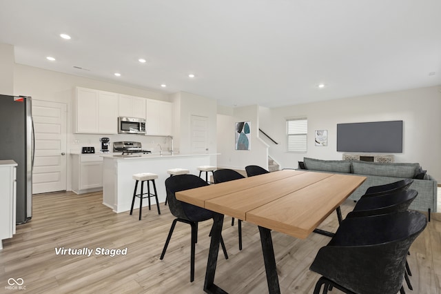 dining area with sink and light hardwood / wood-style floors