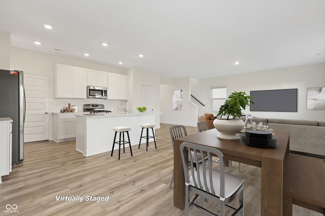 dining area with light hardwood / wood-style floors and sink