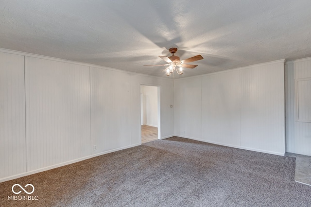 carpeted empty room with ceiling fan, a textured ceiling, and ornamental molding