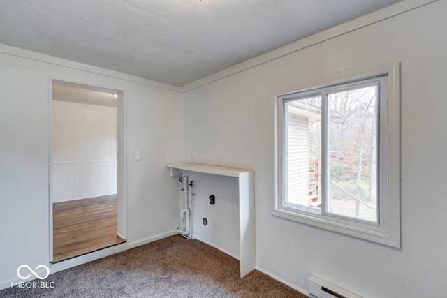 clothes washing area featuring carpet floors, a healthy amount of sunlight, a textured ceiling, and a baseboard heating unit