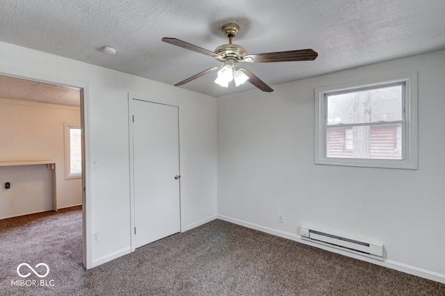 unfurnished bedroom with a baseboard radiator, ceiling fan, multiple windows, and carpet