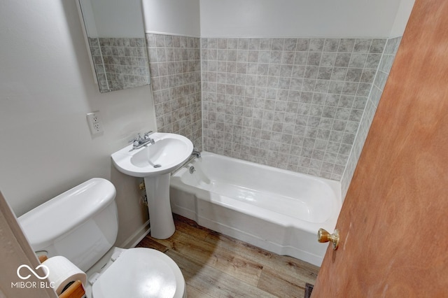 bathroom featuring washtub / shower combination, wood-type flooring, and toilet