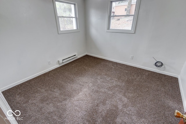 carpeted spare room featuring baseboard heating and a healthy amount of sunlight