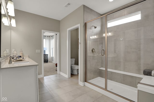 bathroom with tile patterned floors, vanity, toilet, and an enclosed shower