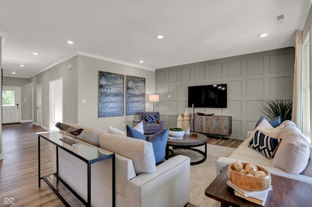 living room featuring light wood-type flooring and crown molding