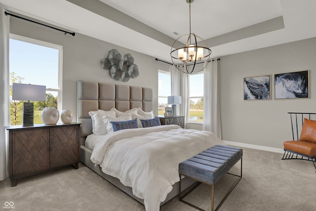 bedroom with a raised ceiling, light colored carpet, and an inviting chandelier