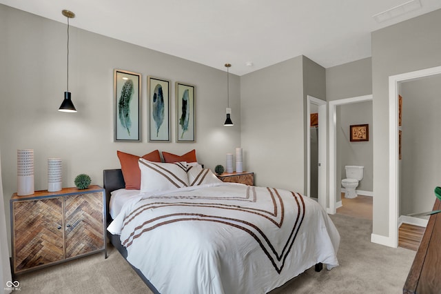 carpeted bedroom featuring ensuite bath