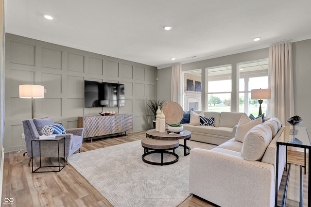 living room featuring light hardwood / wood-style floors and crown molding