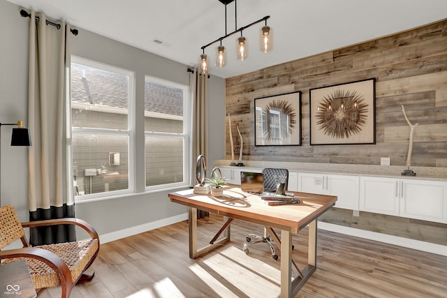 office space with light hardwood / wood-style flooring and wood walls