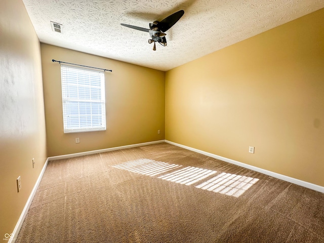 carpeted spare room with a textured ceiling and ceiling fan