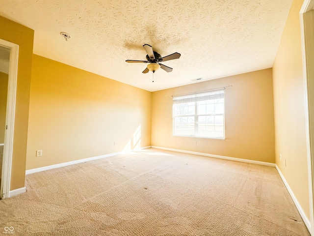 carpeted spare room with a textured ceiling and ceiling fan