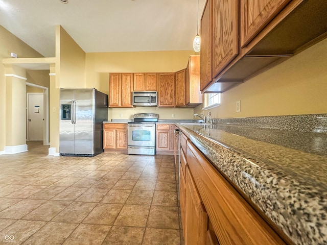 kitchen featuring lofted ceiling, sink, appliances with stainless steel finishes, light tile patterned flooring, and decorative light fixtures