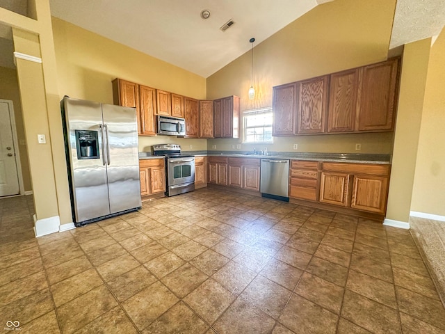 kitchen with pendant lighting, stainless steel appliances, and high vaulted ceiling