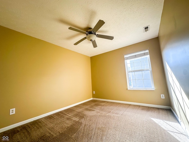 carpeted spare room with ceiling fan and a textured ceiling