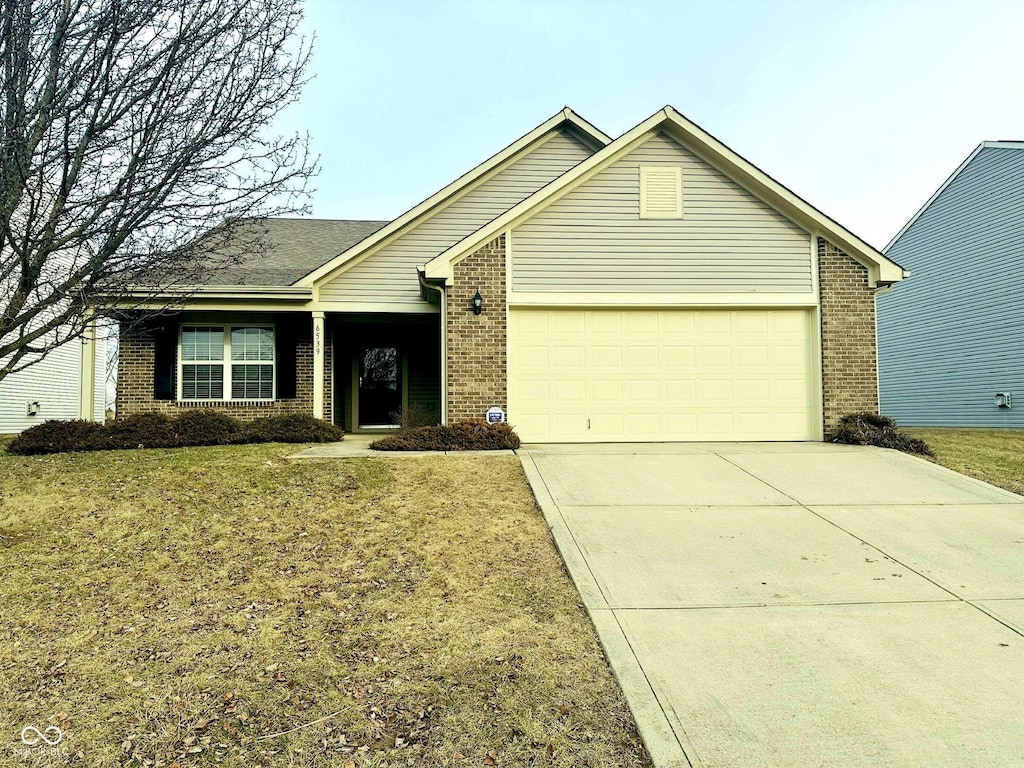 ranch-style home with a garage and a front lawn