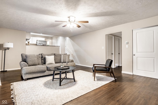 living room with baseboards, ceiling fan, and dark wood-style flooring