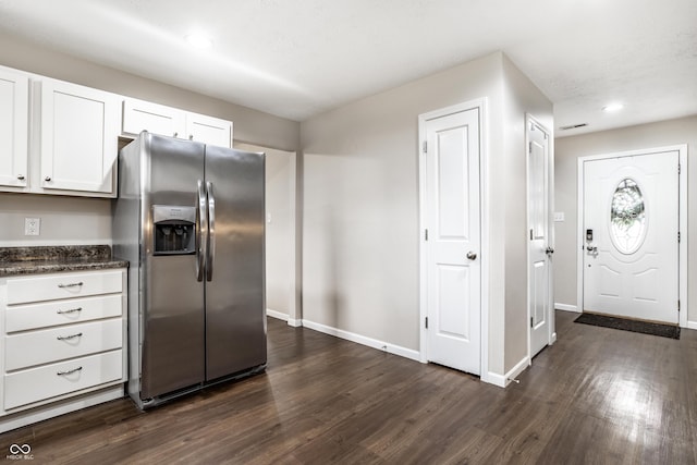 kitchen featuring baseboards, dark wood finished floors, recessed lighting, stainless steel refrigerator with ice dispenser, and white cabinetry