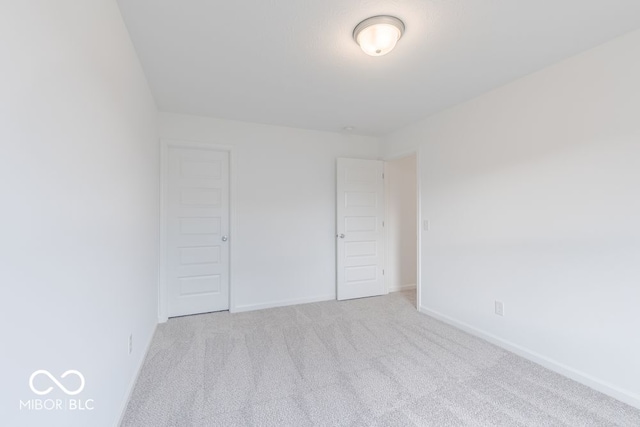 unfurnished bedroom with light carpet and a closet