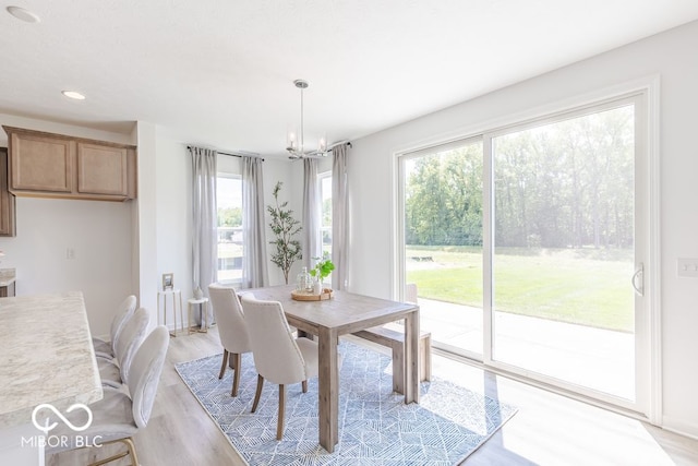 dining area with light hardwood / wood-style flooring and a chandelier