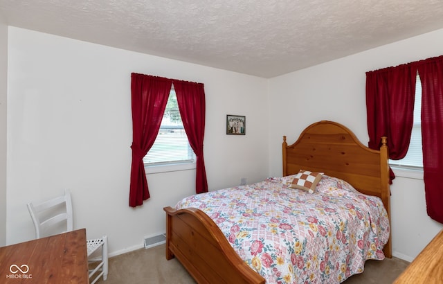 carpeted bedroom featuring a textured ceiling