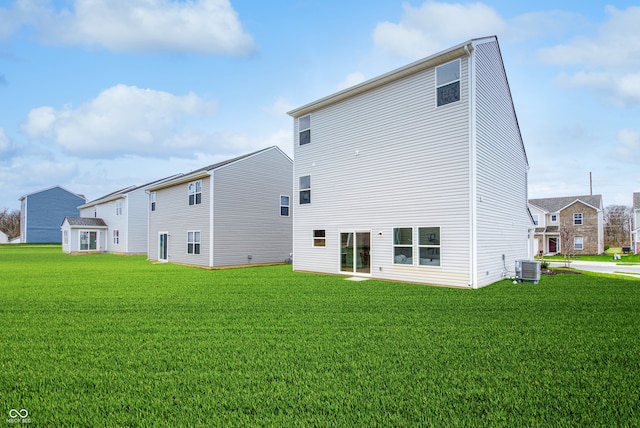 back of property featuring cooling unit and a yard