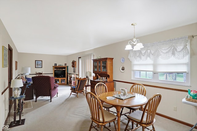 dining space featuring light colored carpet, vaulted ceiling, and a notable chandelier