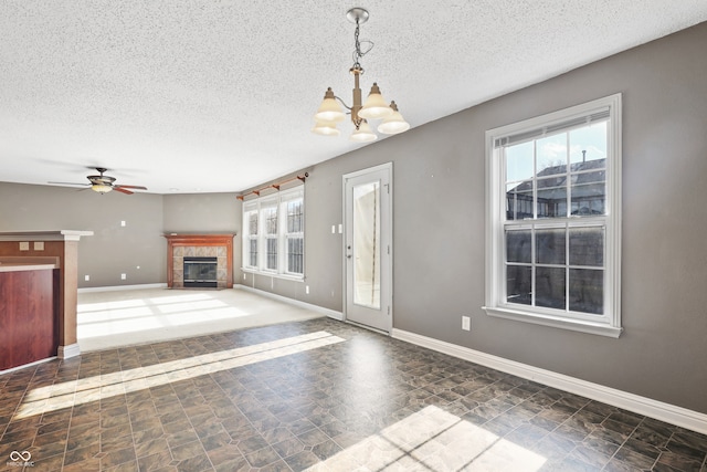 unfurnished living room with a textured ceiling, a fireplace, and a wealth of natural light