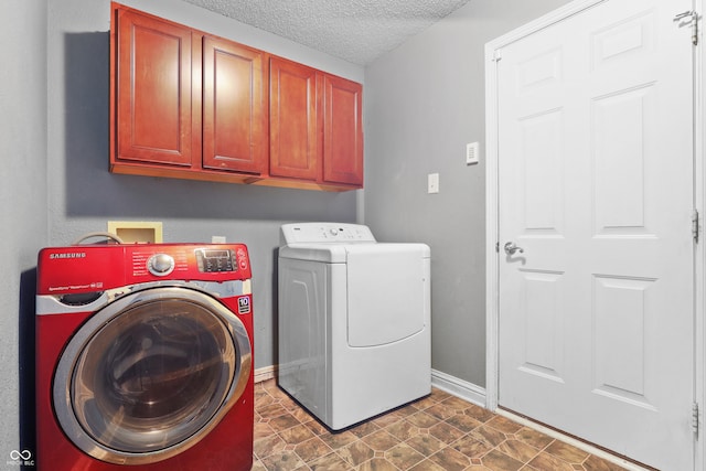 clothes washing area featuring cabinets, a textured ceiling, and separate washer and dryer