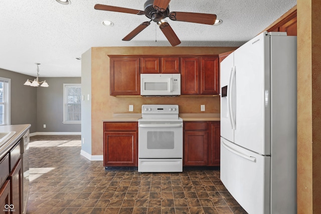 kitchen with a textured ceiling, ceiling fan with notable chandelier, decorative light fixtures, and white appliances