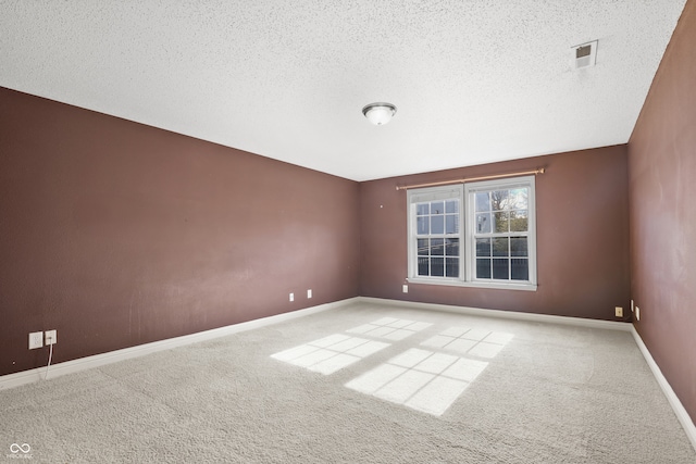 unfurnished room featuring light carpet and a textured ceiling