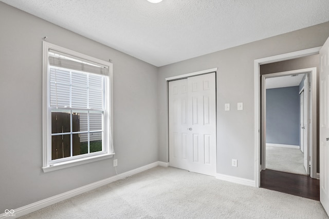 unfurnished bedroom featuring a closet, carpet, and a textured ceiling