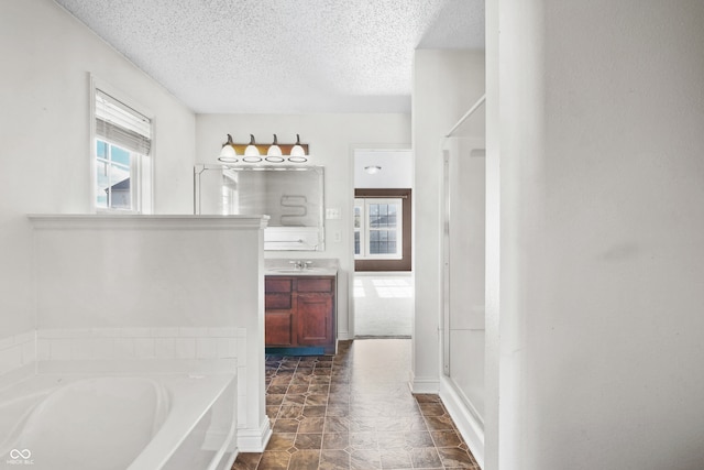 bathroom featuring vanity, a textured ceiling, and shower with separate bathtub