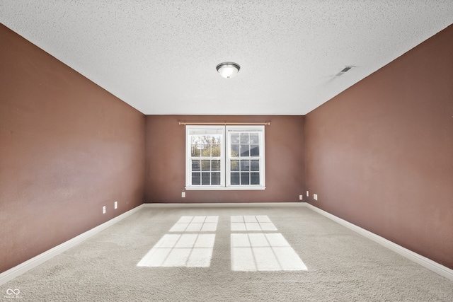 carpeted empty room featuring a textured ceiling